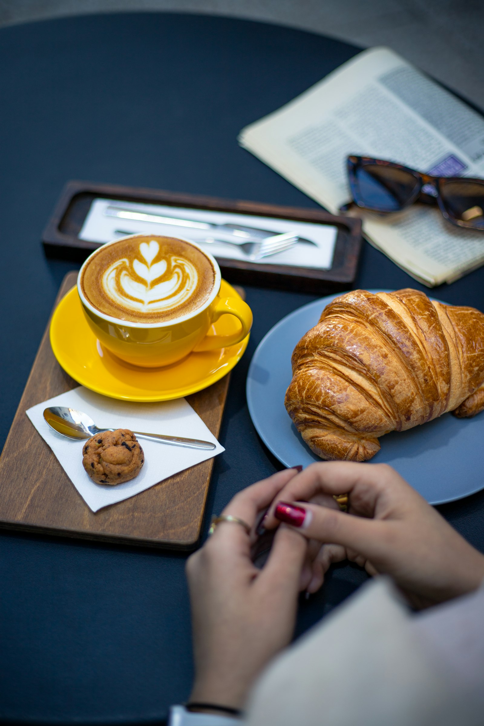 Café con leche y medialuna en la mesa