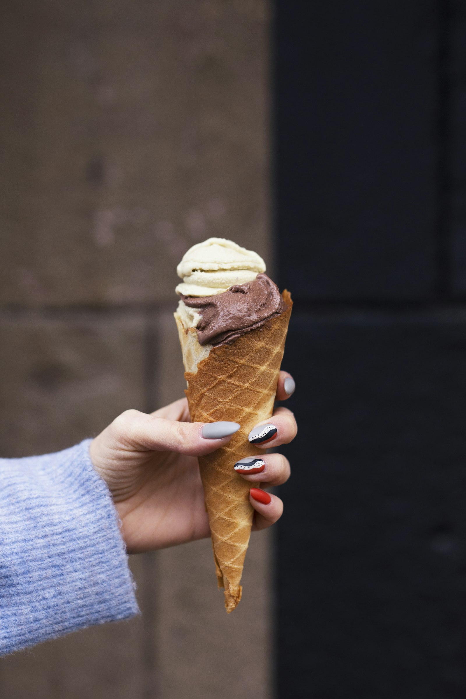 Cucurucho de chocolate y crema americana en mano