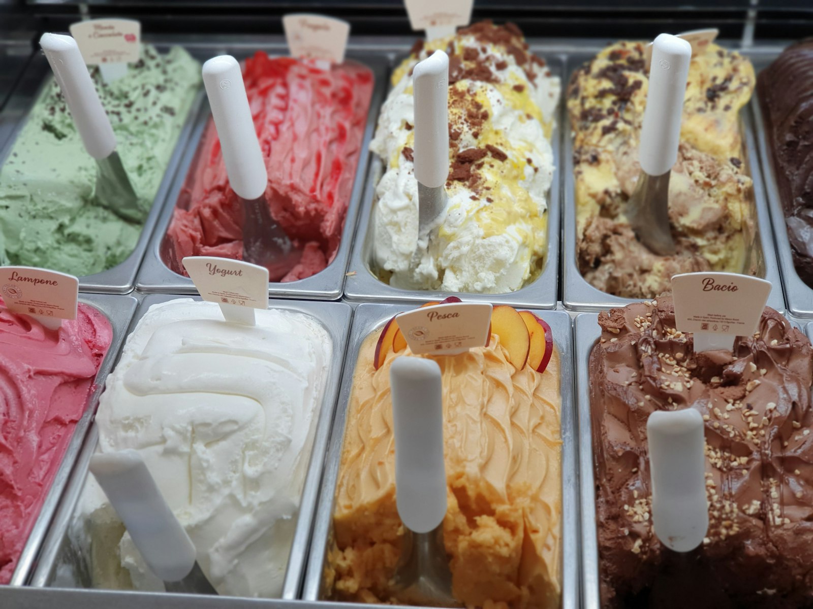 Vitrina de helado artesanal con carteles de sabores italianos